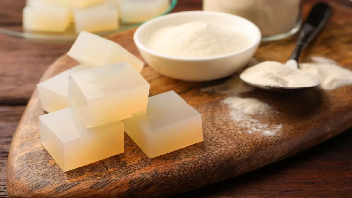 Translucent cubes of agar-agar jelly on a wooden board, next to a bowl of powdered agar-agar