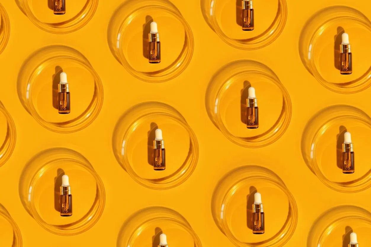 Pattern of perfume sample bottles lined up against a yellow background