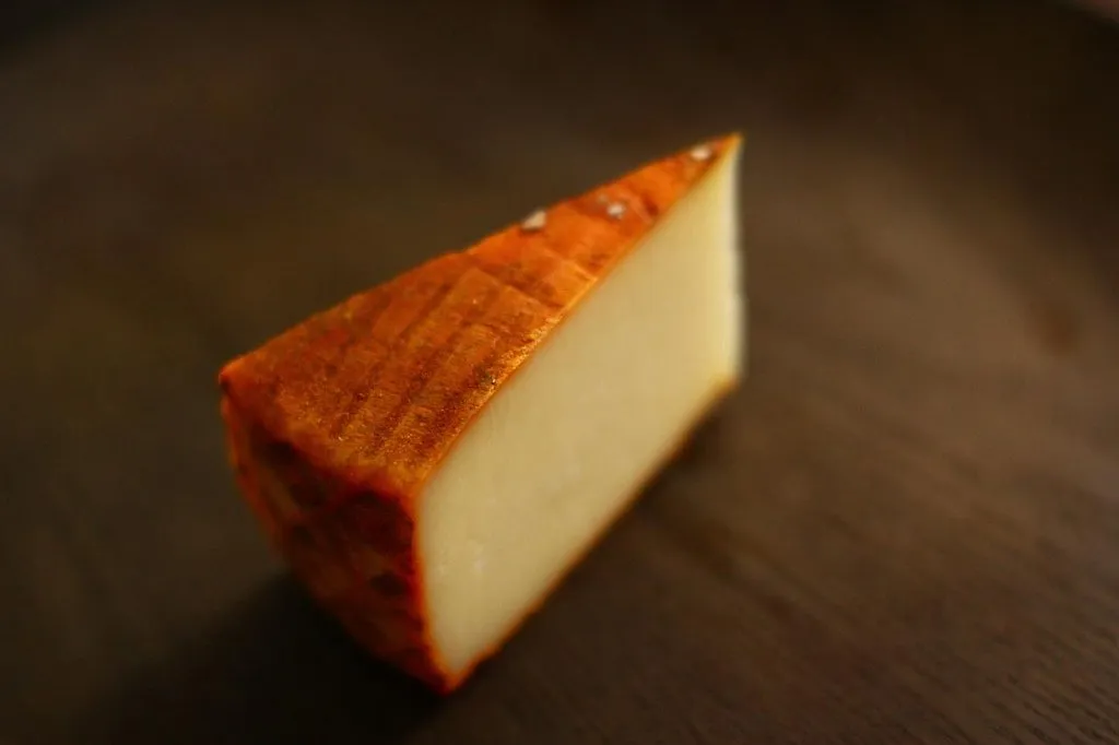 Pieza de queso majorero con marca de pleita en el lateral y pimentón en la corteza