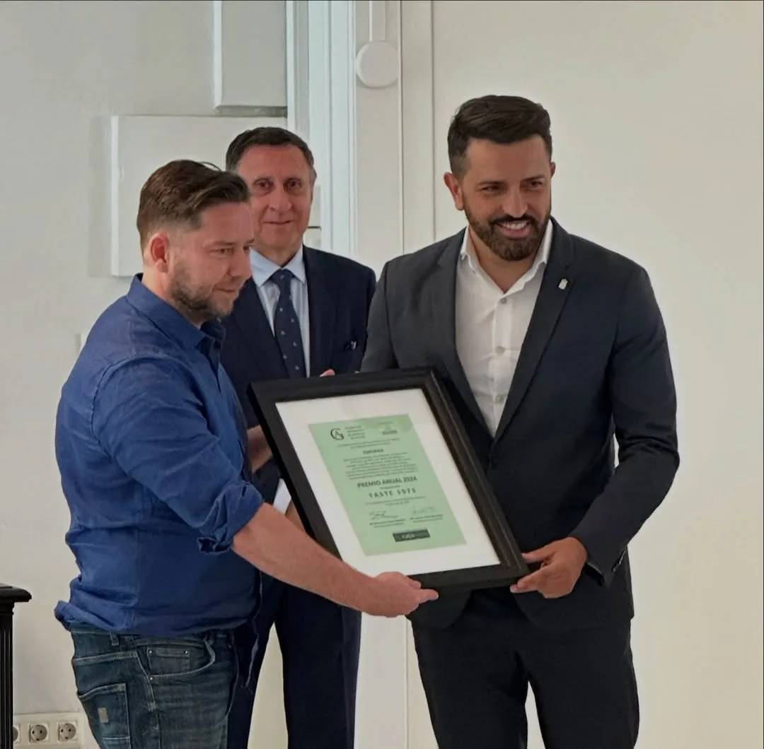 Diego Schattenhofer holds the framed certificate for the 2024 Annual Award granted to Taste 1973