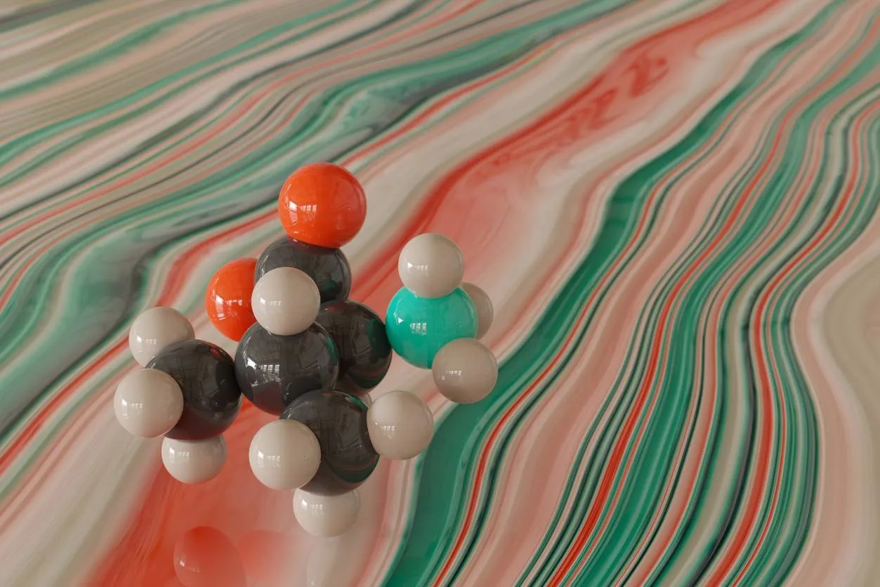 Ball-and-stick molecular model on a marbled green and pink background