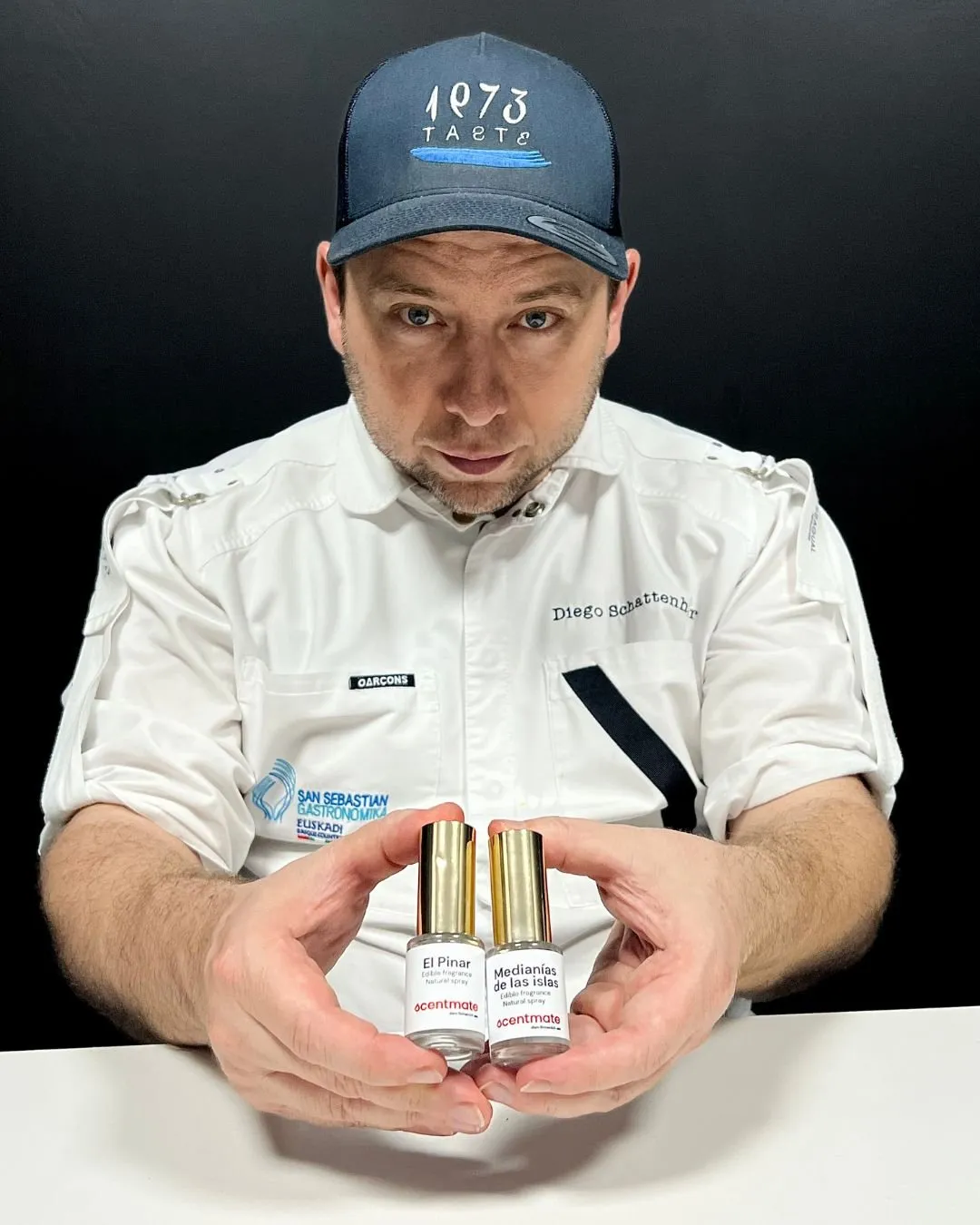 Diego Schattenhofer holding the two edible perfume bottles with both hands