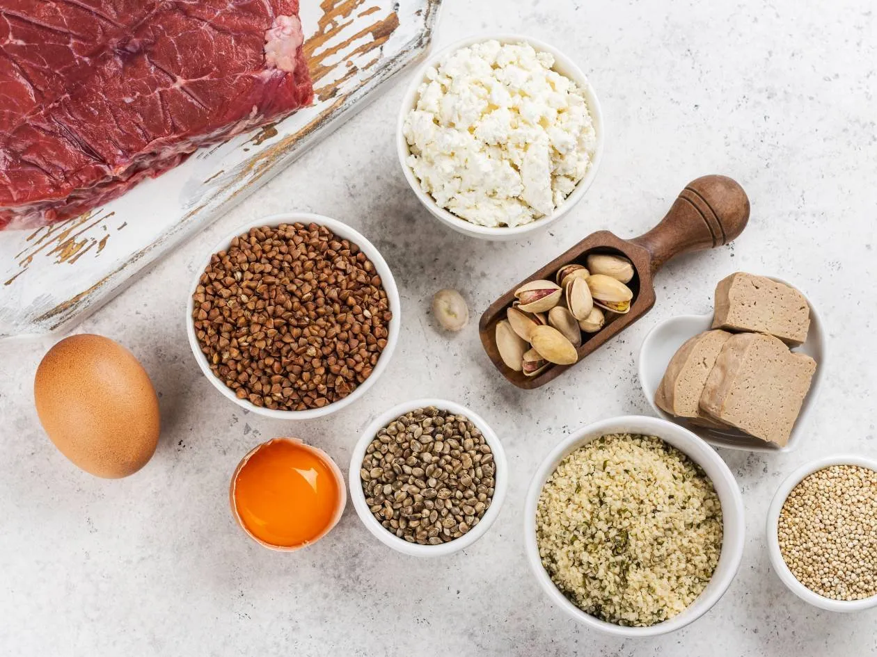 Still life of protein-rich foods: red meat, egg, legumes, seeds, nuts and fresh cheese