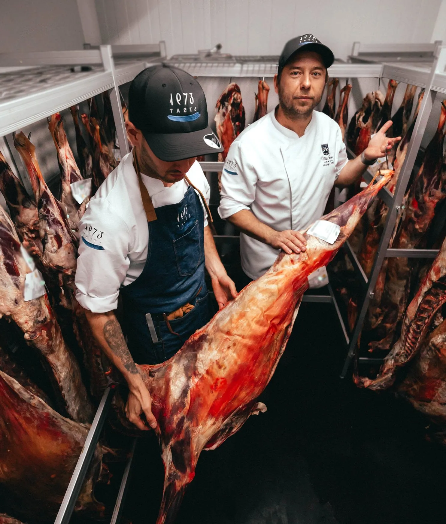 Two Taste 1973 cooks inspect a goat carcass in the ageing chamber