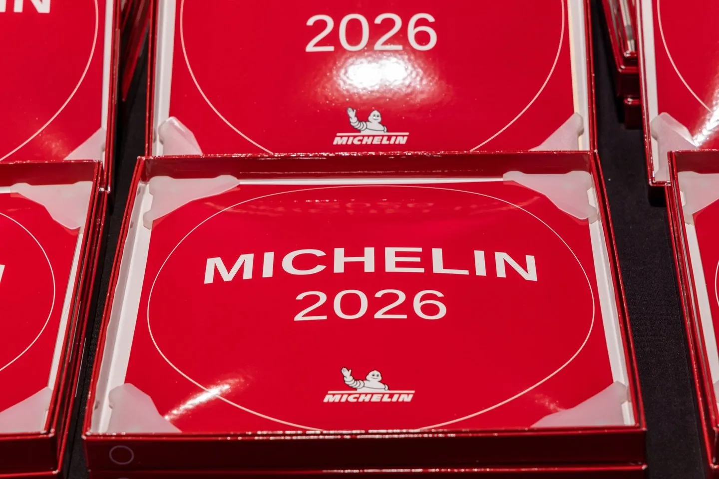 Primer plano de varias placas rojas de la Guía MICHELIN 2026 dentro de sus estuches, alineadas antes de la entrega