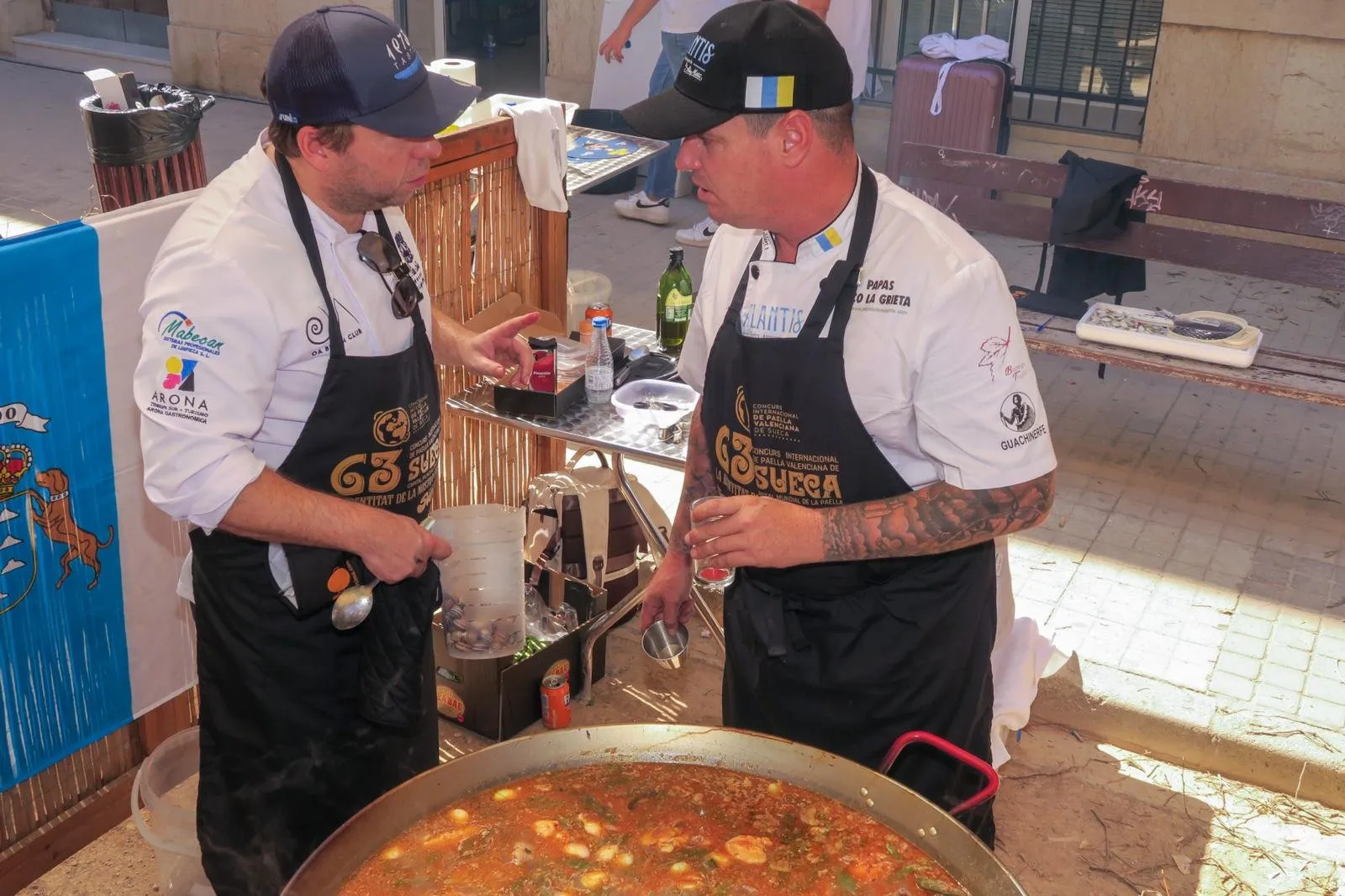 Aday Martín and Diego Schattenhofer talk next to the paella at the Sueca competition