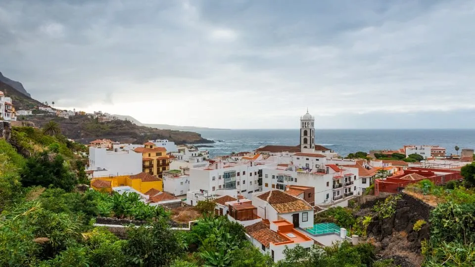 Canarian coastal village of white houses and red roofs by the sea