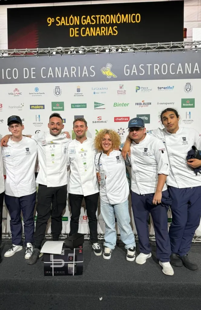 The Taste 1973 team pose in front of the 9th Canary Islands Gastronomic Fair sign