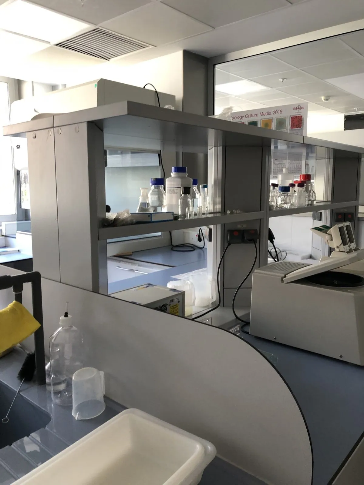 Laboratory bench with an extraction hood, reagent bottles and a washing sink