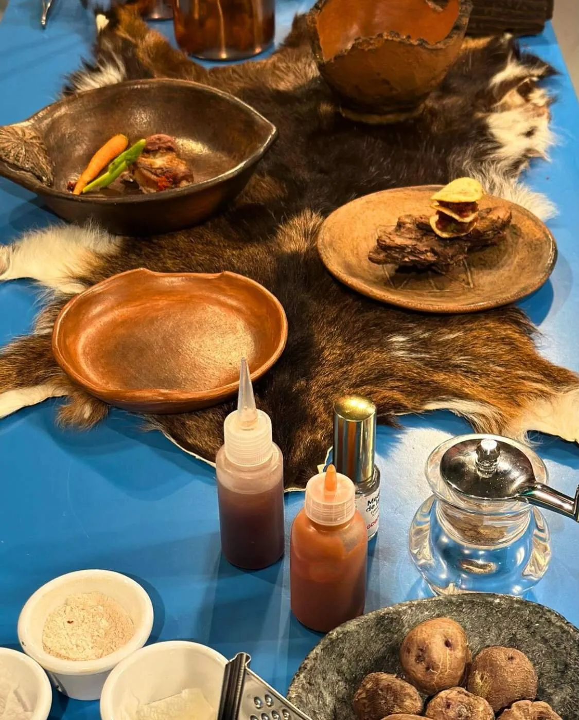 Still life of matured goat meat, potatoes and sauces on a goat hide