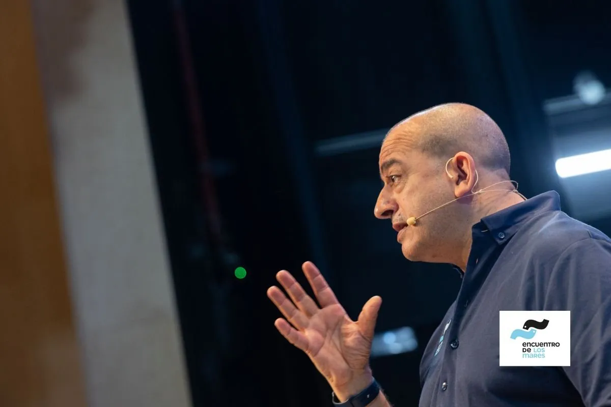 Speaker with a headset microphone gesturing during his talk