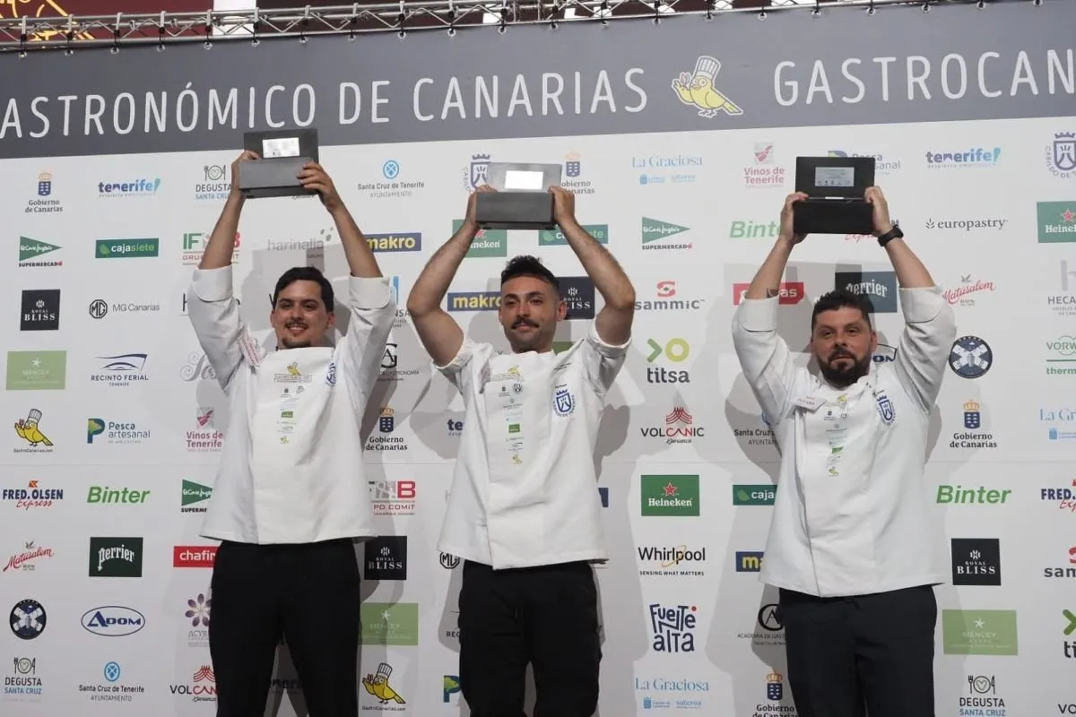 The three championship finalists raise their trophies on the podium