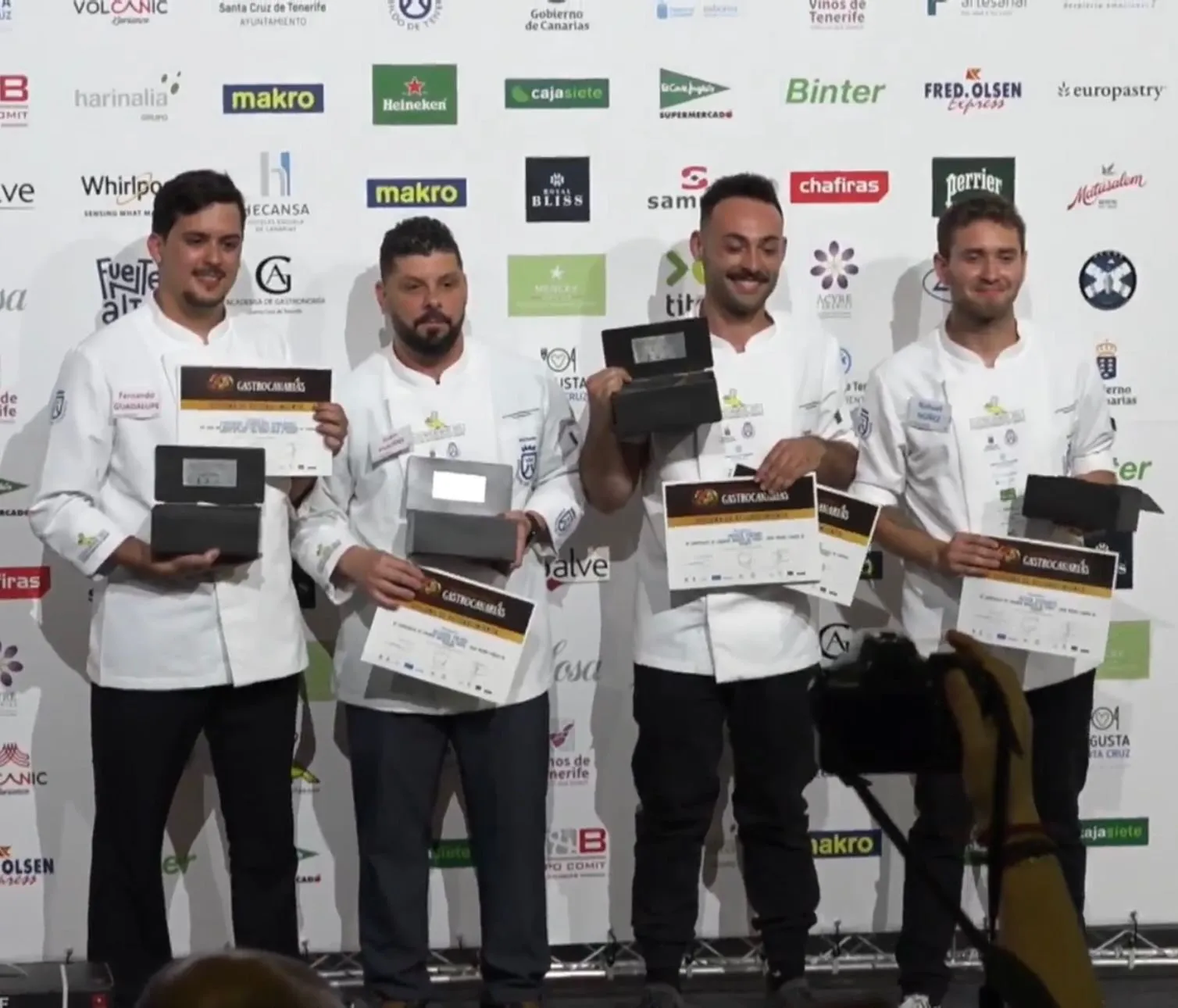 The winning chefs pose with their diplomas and trophies on stage