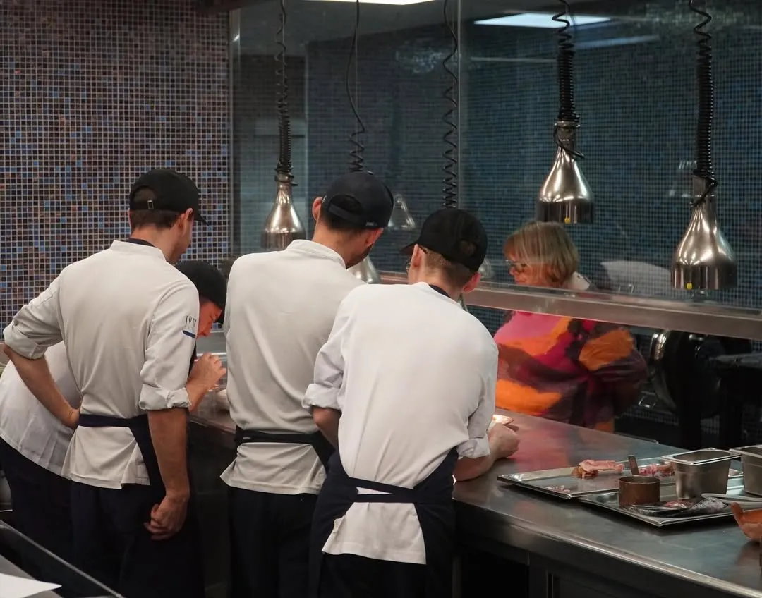 Cooks working the pass under the heat lamps