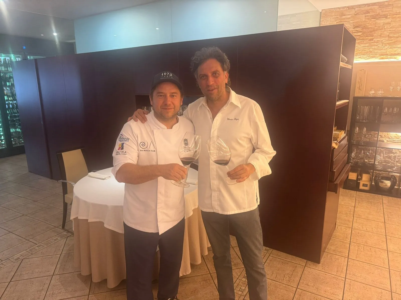Diego Schattenhofer and Vicente Rioja toast with red wine in the dining room