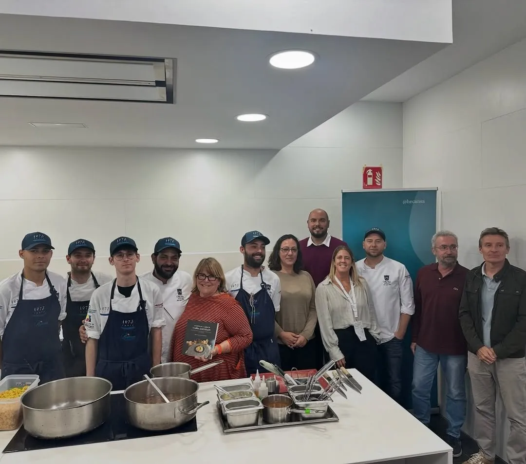 The project team pose with the book in the kitchen classroom