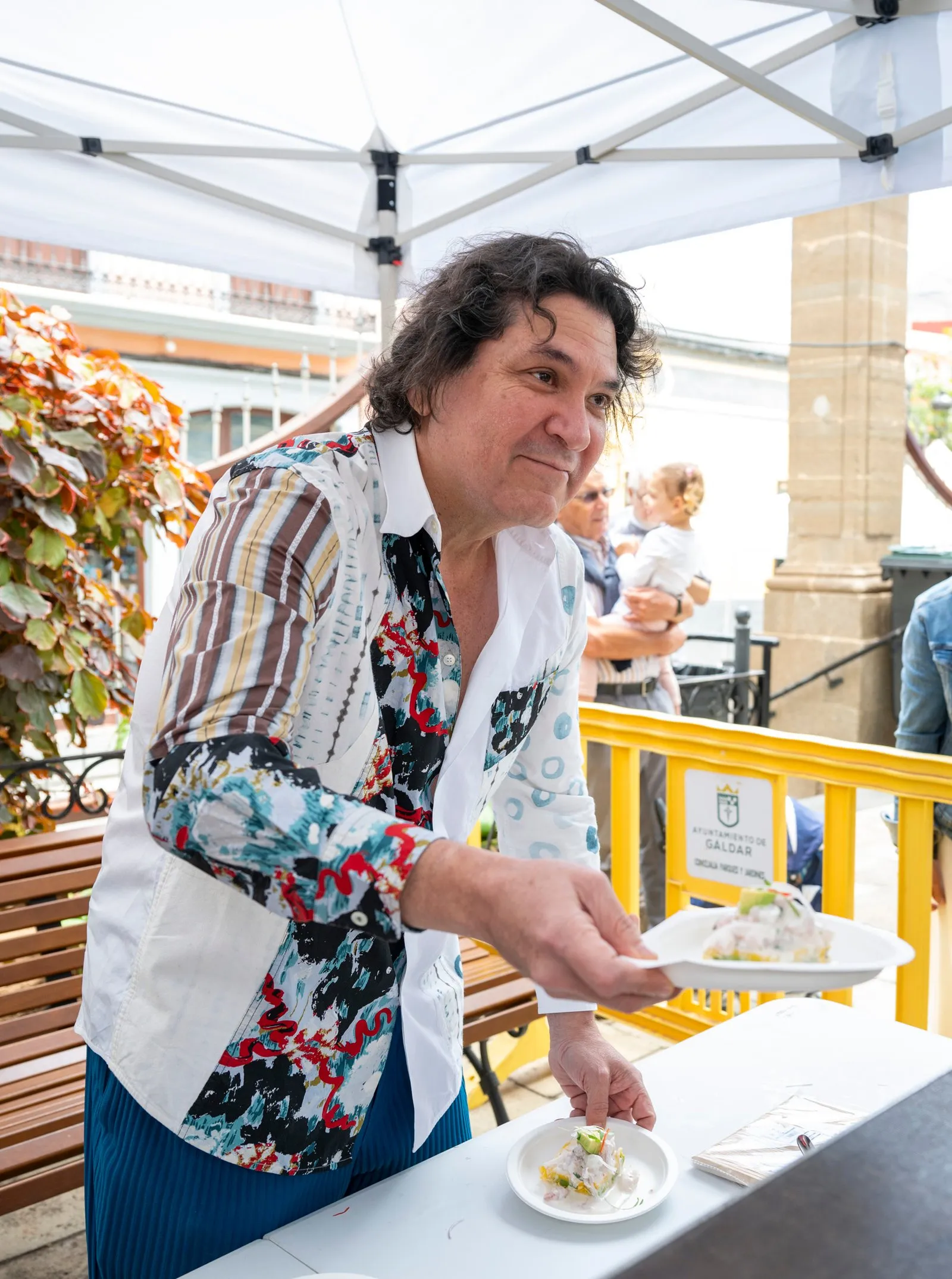 Chef Gastón Acurio serves a plate at the Comida Popular stall