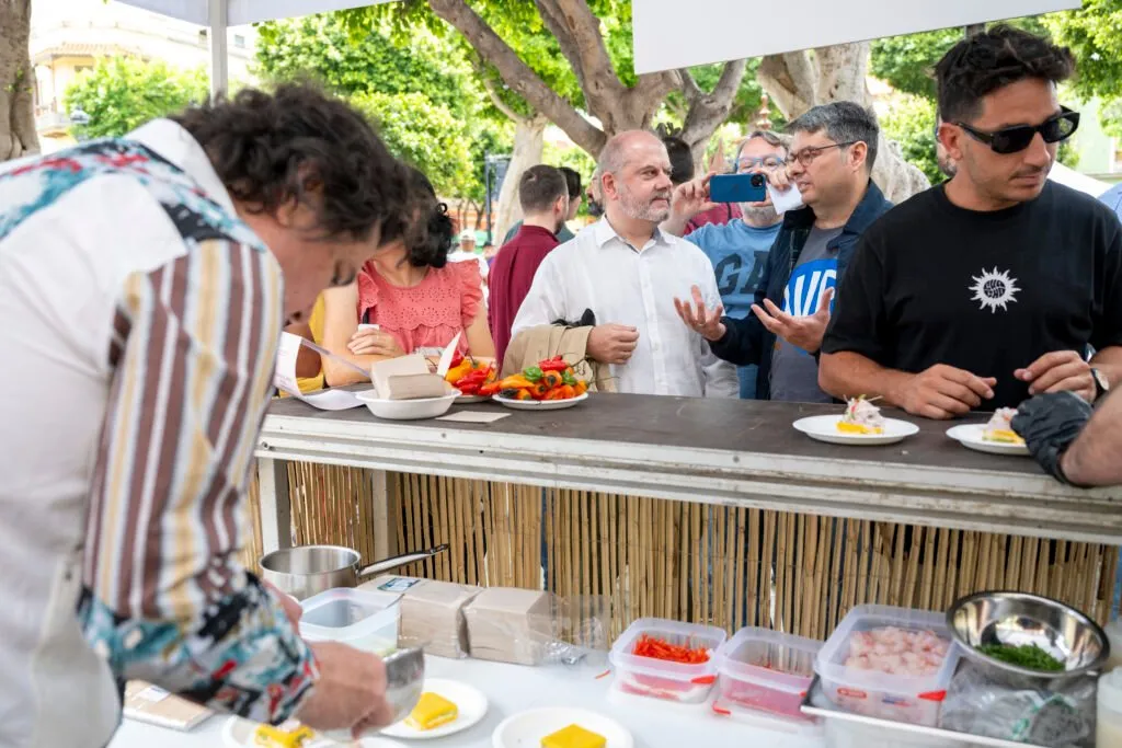 Chef Gastón Acurio serving across the counter while several attendees wait for their plate