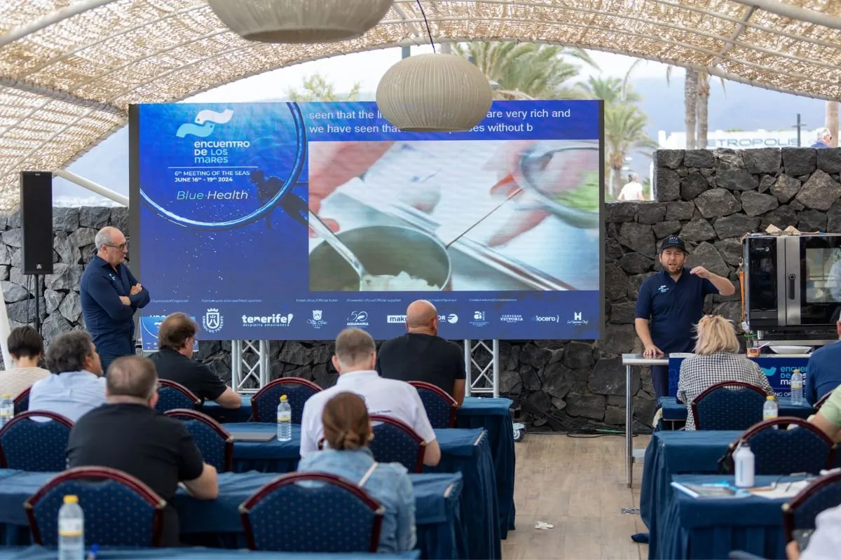 Session under a marquee with attendees facing the congress screen
