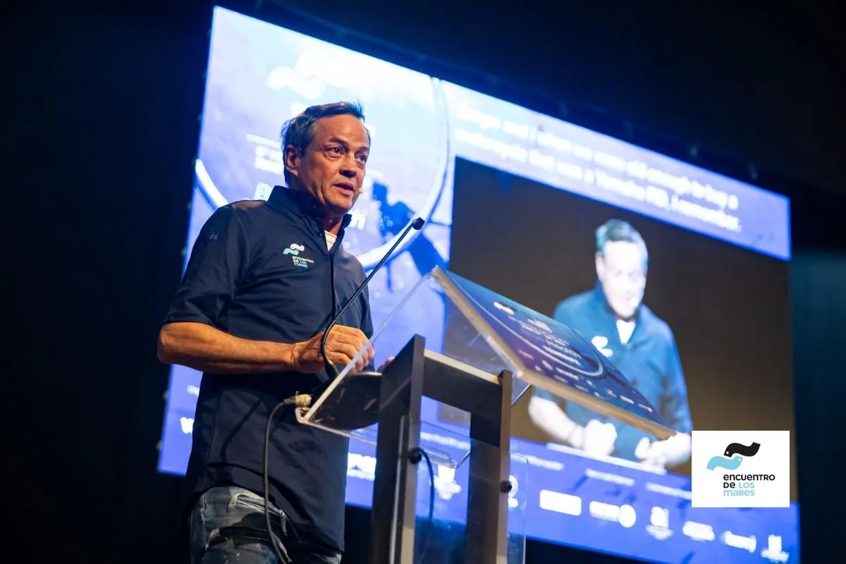 Speaker at the lectern while the screen enlarges his talk