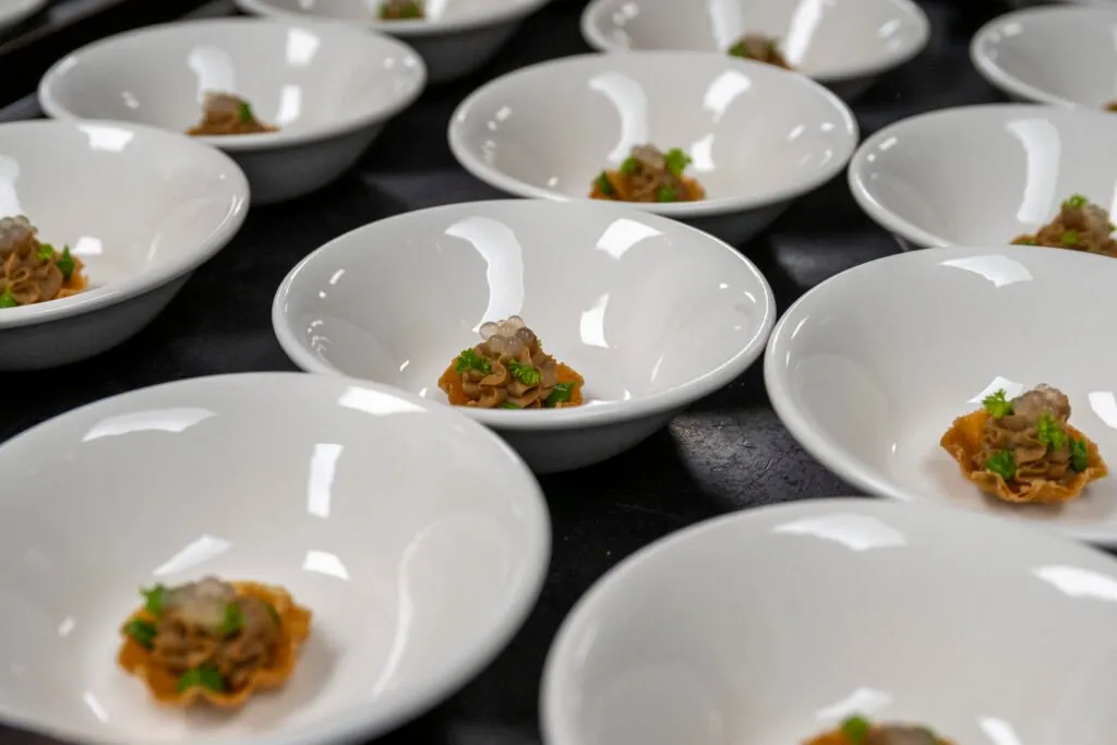 White bowls with small portions of stew ready to be served