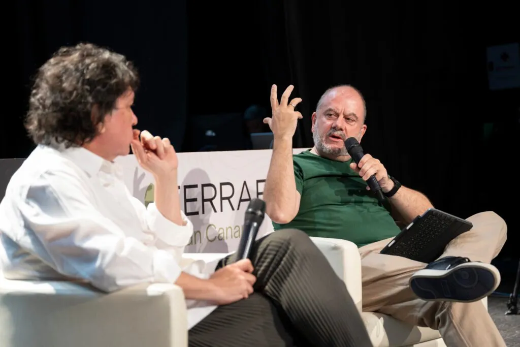 Gastón Acurio talking with another participant seated on stage