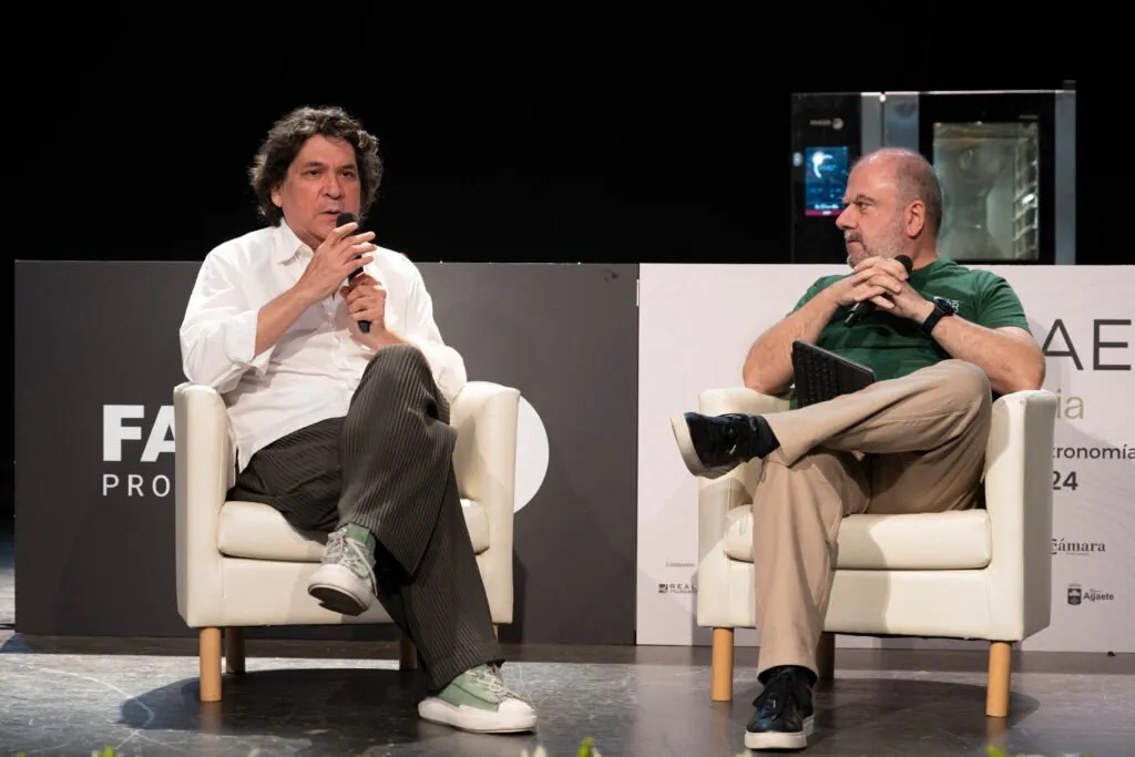 Gastón Acurio and his interlocutor seated in armchairs on stage