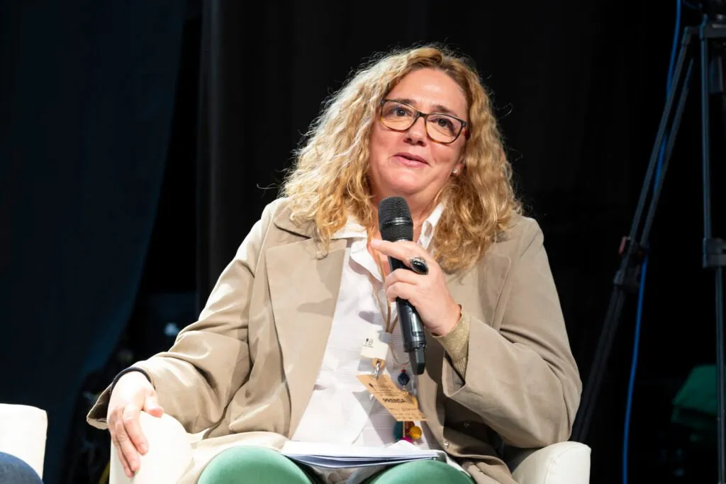 A female speaker addressing the audience with the microphone during the round table