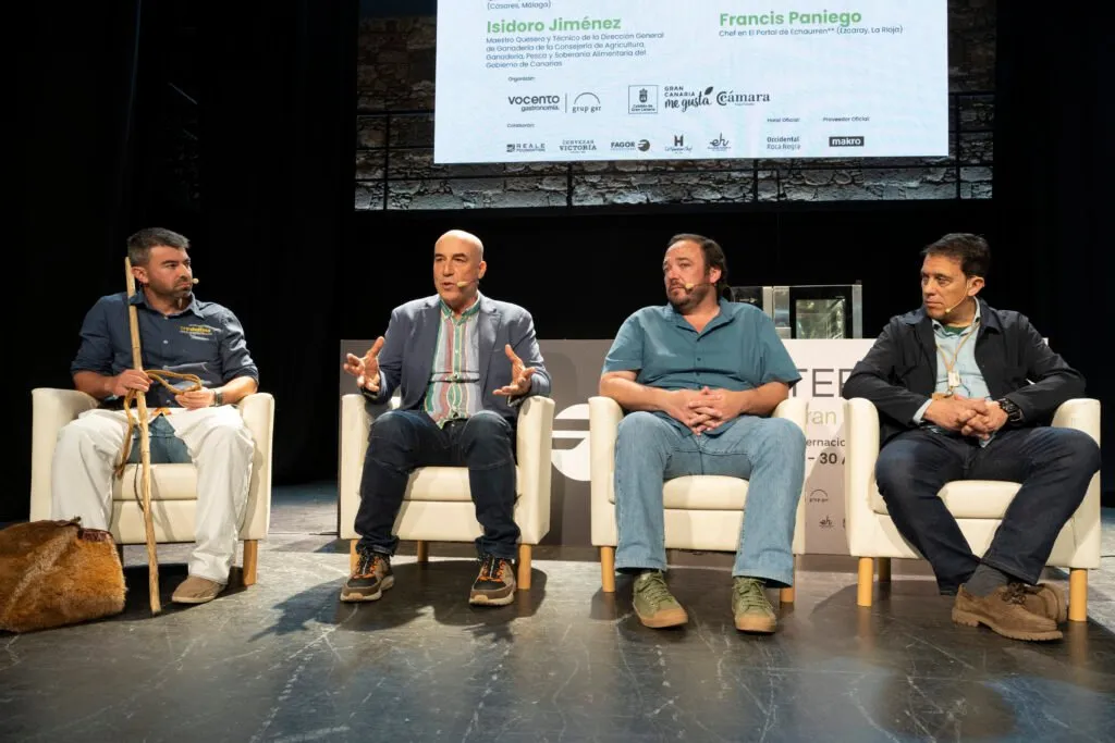 Round table with four participants seated on stage