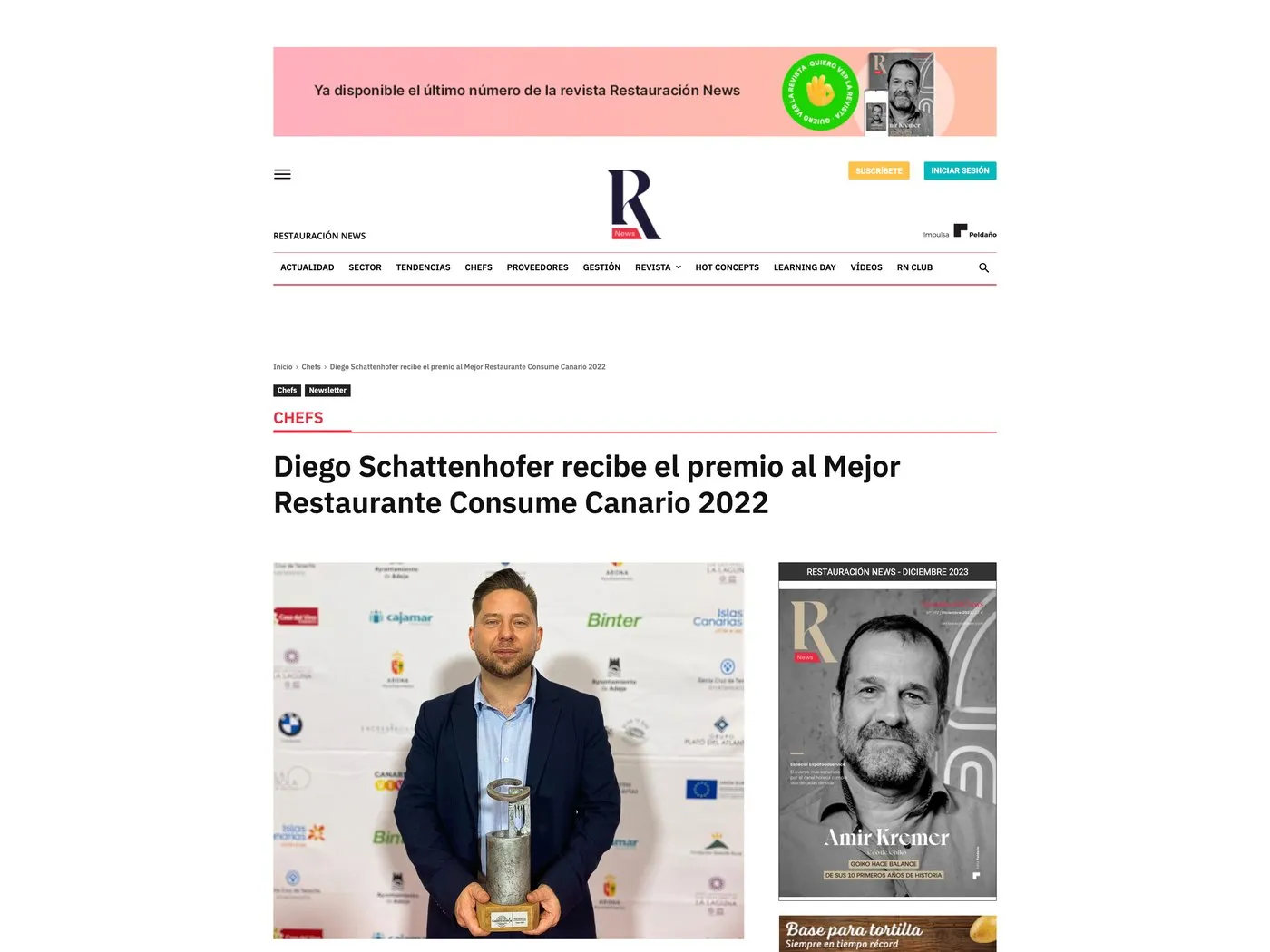 Screenshot of the Restauración News article, with Diego Schattenhofer holding the Consume Canario 2022 award trophy in front of a panel of sponsors
